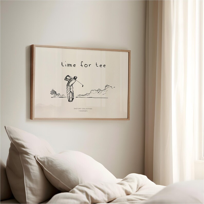 May include: A framed print with a golf theme. The artwork features a sketch of a golfer mid-swing, with the words "time for tee" above. The print is in a light wood frame and hangs on a white wall.