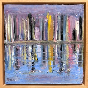 May include: Abstract landscape painting with vertical brushstrokes in shades of purple, yellow, black, and pink, reflected in a blue and purple water. The artwork is signed "MAKELA" in the lower left corner and framed in a light wood.