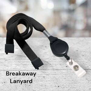 May include: Black breakaway lanyard with a retractable badge holder. The lanyard is made of a woven fabric and has a black plastic clip. The badge holder is made of black plastic and has a silver metal clip.