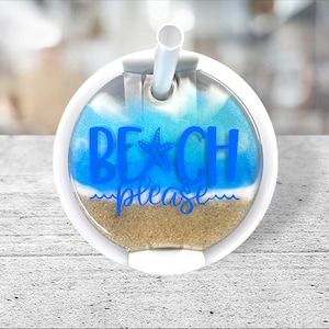 May include: White tumbler lid with a blue and white beach scene and the text "BEACH please" in blue. The lid has a hole for a straw.