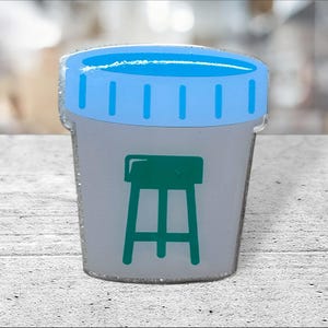 May include: A white pill bottle with a blue lid and a green stool graphic on the front.