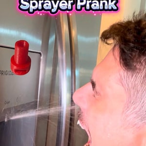 May include: A red plastic fridge water sprayer prank device. The device is positioned near a stainless steel refrigerator, with the text "Fridge Water Sprayer Prank" in a pink and white font.