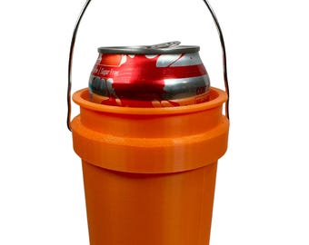 May include: Orange plastic bucket with a metal handle and a can of soda inside. The bucket has a lip around the top to hold the can in place.