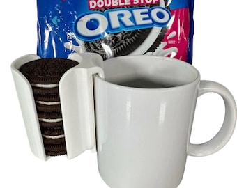 May include: A white ceramic mug with a handle, a white plastic Oreo cookie holder, and a package of Double Stuf Oreo cookies. The holder is attached to the mug and holds a stack of chocolate sandwich cookies.