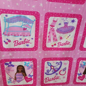 May include: Pink fabric with repeating square patterns featuring Barbie illustrations. Each square has a pink border and a white interior with images of Barbie, a bed, clothing, and accessories. The background is a lighter pink with white starbursts.