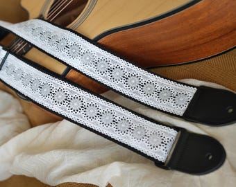 Correa de guitarra tejida con estampado floral en blanco y negro. Personaliza el color de los herrajes de metal y los extremos de cuero. Personaliza tu propia correa de guitarra.