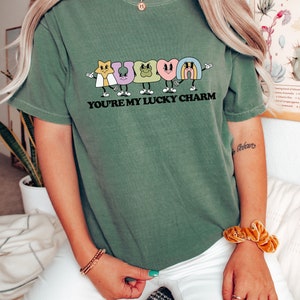 May include: A green t-shirt with a graphic of cartoon lucky charms and the text "You're my lucky charm".