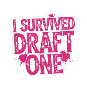 Puede incluir: Una pegatina rosa con el texto "I SURVIVED DRAFT ONE" en una fuente audaz y desgastada. La pegatina tiene un borde blanco y detalles de salpicaduras de pintura rosa. Un pequeño corazón está encima de la palabra "SURVIVED".