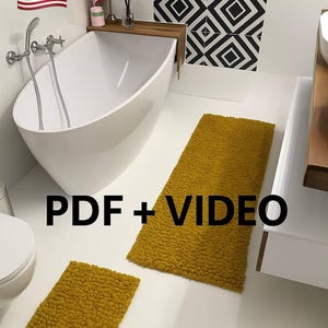 May include: A modern bathroom with a white, oval-shaped bathtub and two mustard-yellow bath mats. The walls are white with a black and white geometric tile pattern. The image includes the text "PDF + VIDEO".