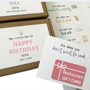 May include: A gift box set with a birthday theme. The box features a label that reads "The Little Box of HAPPY BIRTHDAY Gifts." A gift card for a restaurant is visible. Other cards suggest activities like "need a fun activity" and "don't want to cook."