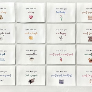 May include: Set of 16 blank cards with watercolor illustrations and text that reads "open when you..." followed by a reason to open the card.  The reasons include "need a hug", "miss us", "feel lonely", "want to see a movie", "need a study break", "need a laugh", "are happy", "want to order in", "feel sick", "need coffee", "want to get a sweet treat", "need extra cash", "need encouragement", "feel stressed", "want to get breakfast", and "want to get dinner".