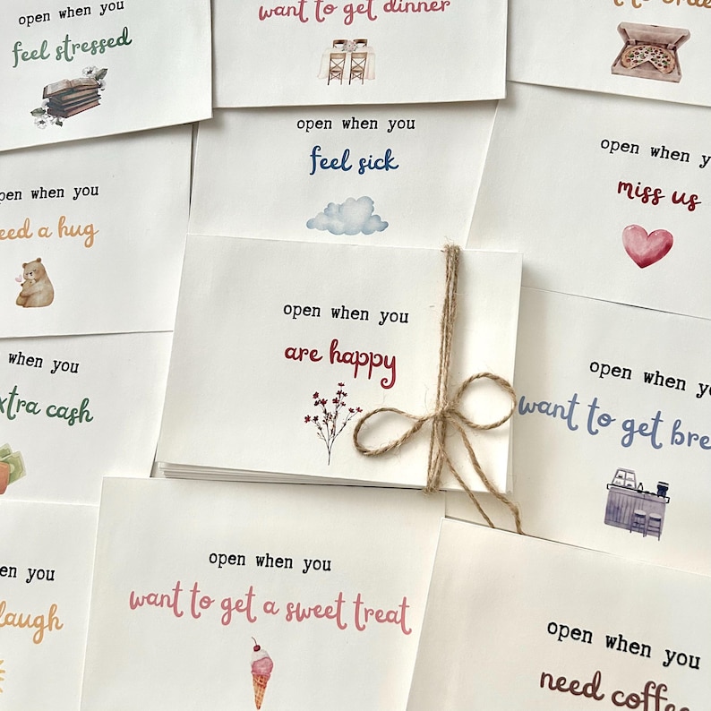 May include: A set of ten cards with watercolor illustrations and encouraging messages. Each card has a different message, such as "open when you feel stressed", "open when you want to get dinner", "open when you feel sick", "open when you are happy", "open when you miss us", "open when you want to get breakfast", "open when you want to get a sweet treat", "open when you need coffee", "open when you need a hug", and "open when you need extra cash".
