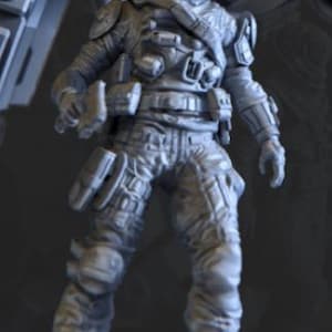 Op de afbeelding: Een grijze figuur van een futuristische soldaat in een gevechtspak. De figuur draagt een helm, lichaamsbescherming en tactische uitrusting, inclusief zakjes en een zijwapen. De soldaat staat in een neutrale houding.