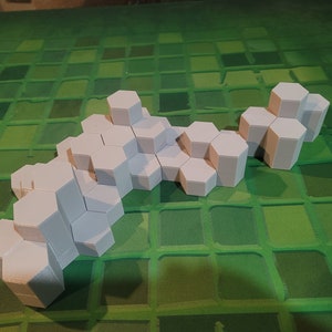 May include: A white honeycomb structure made of hexagonal blocks. The structure is arranged in a curved shape, resembling a wave or a flowing river.