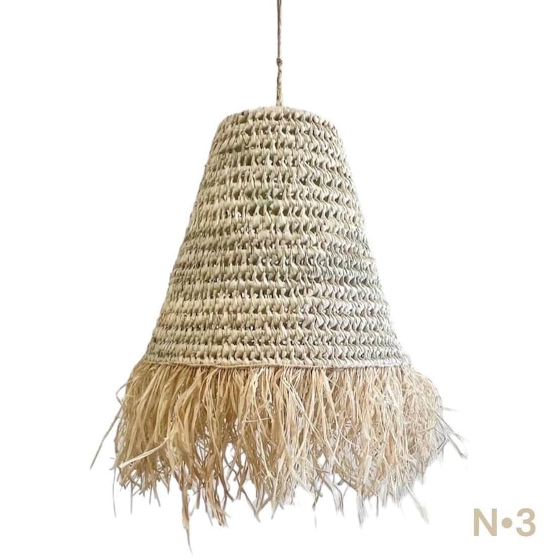 May include: A natural woven pendant light with a fringe trim. The light is made of a natural material and has a light brown color.