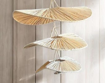 Peut inclure: Un ensemble de trois lampes suspendues en forme d'éventail, en paille tressée, suspendues à un plafond. Les lumières sont disposées en spirale.
