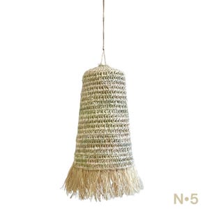 May include: A natural woven pendant light with a fringed bottom. The light is made of a light beige material and has a bell shape.
