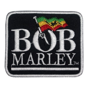 Puede incluir: Parche bordado en blanco y negro con el texto "BOB MARLEY" y una bandera roja, amarilla y verde con un diseño de pájaro.