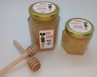 May include: Two glass jars of honey scrub with gold lids. The jars are labeled "Yoni Honey Scrub" and feature a cartoon illustration of a woman. The larger jar is 4 oz and the smaller jar is 2 oz. A wooden honey dipper is included.