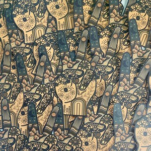 May include: A collection of die-cut stickers shaped like a hand making a peace sign. Each sticker features a tan background with dark blue line art depicting flowers, a central eye, a crescent moon, butterflies, and the word PEACE on the thumb.