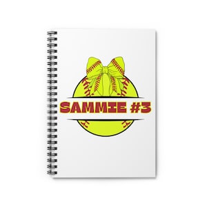 May include: A white spiral notebook with a yellow softball with a red bow and the text "SAMMIE #3" on it.