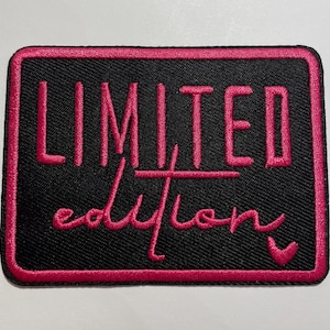 May include: A rectangular embroidered patch with a black background and a hot pink border. The text LIMITED is stitched in hot pink block letters above the word edition in a hot pink cursive script, finished with a small heart icon.