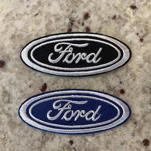 May include: Two embroidered Ford logos, one with a black background and white stitching, and the other with a blue background and white stitching.
