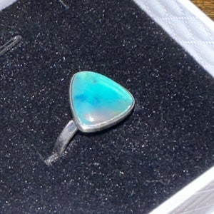 May include: A silver ring with a triangular blue opal gemstone.