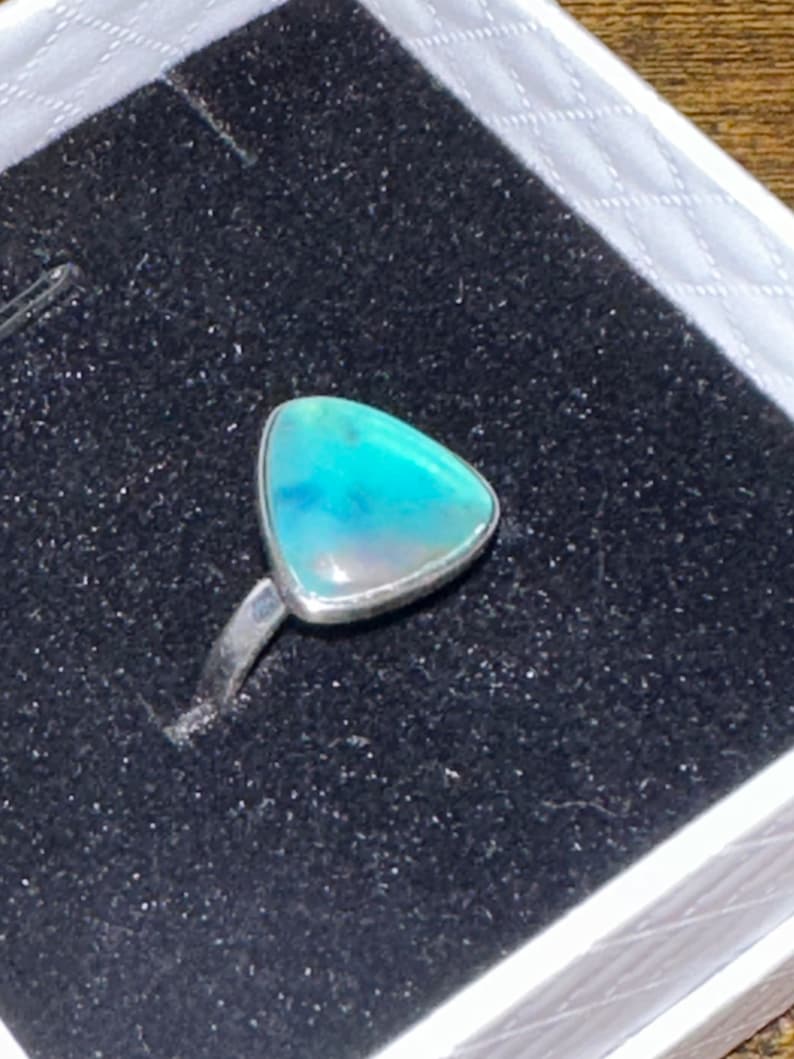 May include: A silver ring with a triangular blue opal gemstone.