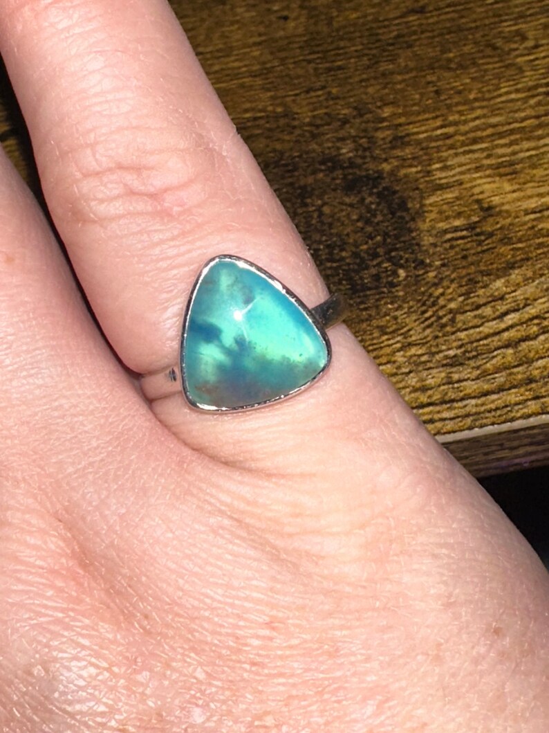 May include: A silver ring with a triangular green and blue opal gemstone.