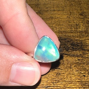 May include: A silver ring with a triangular blue opal gemstone.