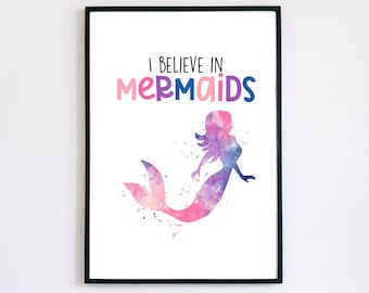 Puede incluir: Una impresión enmarcada con una ilustración de acuarela de una sirena con el texto "Creo en sirenas" en rosa, azul y morado.