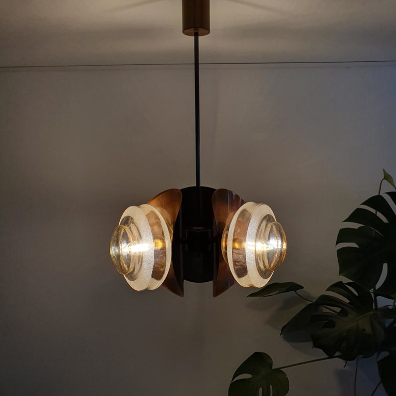 May include: A modern, mid-century style chandelier with a black metal frame and two frosted glass globes. The chandelier has a minimalist design and is perfect for a contemporary home.