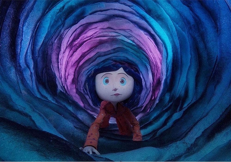 May include: A young girl with blue eyes and dark hair crawls through a swirling, multi-colored tunnel. The tunnel is made of layered, textured paper, with shades of blue, purple, and pink.
