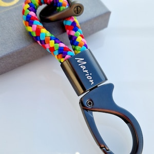 以下が含まれることがあります： レインボーの編組ロープと「マリオ」と刻まれたパーソナライズされたネームタグが付いた、黒い金属製のキーホルダーです。