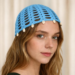 May include: A light blue crocheted hat with a shell trim. The hat has an open weave design and is adorned with small, white seashells along the brim. The hat is a stylish accessory.