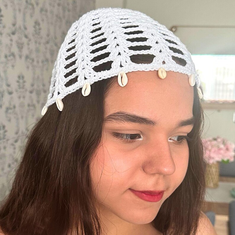 May include: White crochet hat with a shell trim. The hat is made of a delicate, open-weave fabric and has a simple, elegant design.