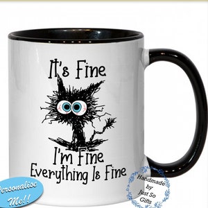 May include: White ceramic mug with a black rim and handle. The mug features a black and white cartoon cat with the text "It's Fine I'm Fine Everything Is Fine".