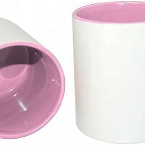 Peut inclure: Deux mugs en c&eacute;ramique blanche avec un int&eacute;rieur et une anse roses. L'un des mugs est droit, l'autre est inclin&eacute; pour montrer l'int&eacute;rieur. Les mugs sont con&ccedil;us pour les boissons chaudes.