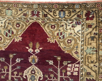Könnte beinhalten: Nahaufnahme eines roten und cremefarbenen Teppichs mit komplizierten Blumenmustern. Der Teppich hat einen Rand mit einem sich wiederholenden Muster.