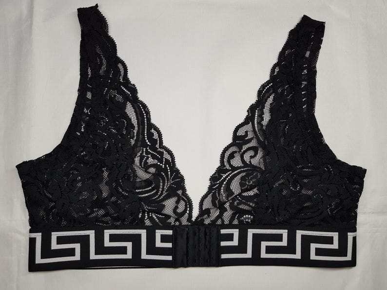 May include: Black lace bralette with a V-neck design. The bralette features a decorative white and black geometric pattern along the bottom band. The bra has adjustable straps and a hook-and-eye closure in the back.