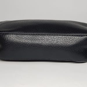 Pu&ograve; includere: Una borsa a tracolla in pelle nera con superficie strutturata. La borsa ha una forma rettangolare con bordi arrotondati e una tracolla a catena color oro. La borsa &egrave; mostrata su sfondo bianco.