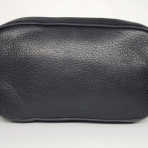 Pu&ograve; includere: Una borsa a tracolla nera rettangolare con esterno in pelle strutturata. La borsa ha una tracolla a catena e finiture color oro. La borsa misura circa 20 cm di larghezza e 15 cm di altezza.