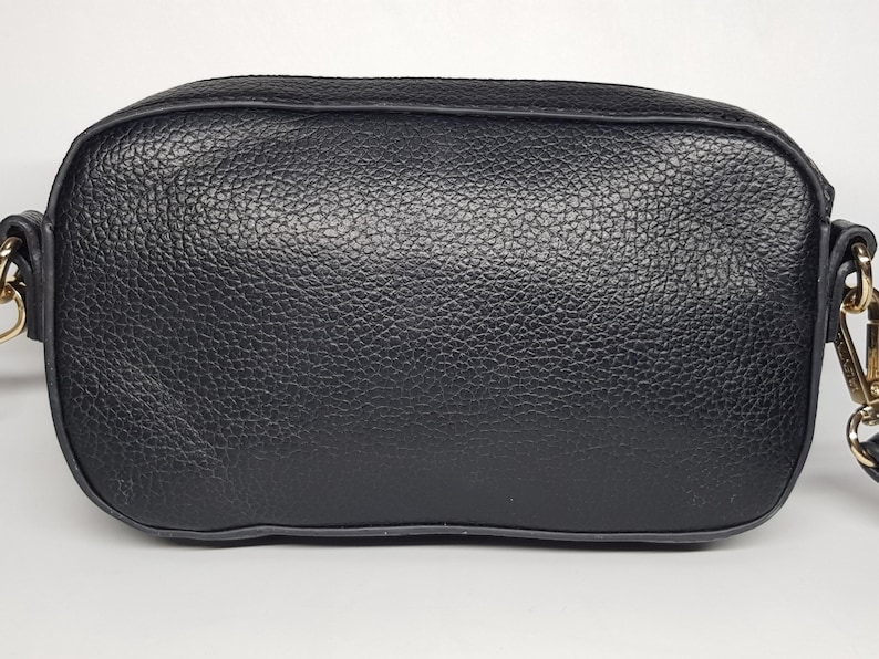 Pu&ograve; includere: Una borsa a tracolla nera rettangolare con esterno in pelle strutturata. La borsa ha una tracolla a catena e finiture color oro. La borsa misura circa 20 cm di larghezza e 15 cm di altezza.