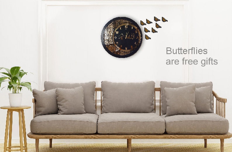 K&ouml;nnte beinhalten: Eine schwarze Uhr mit goldenem Design und einer Halbmondform. Die Uhr ist von einem Schwarm goldener Schmetterlinge umgeben. Der Text "Butterflies are free gifts" steht unter der Uhr.