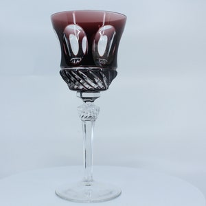 Könnte beinhalten: Ein klares Weinglas mit tiefem Purpurton und aufwendigem geschnittenem Glasdesign.