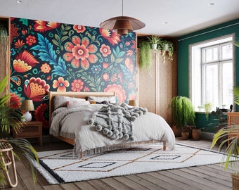 May include: A bedroom with a bohemian style featuring a bed with a white duvet and a gray throw blanket with pom-poms. The headboard is against a wall with a colorful floral mural. The room has a wooden floor and several plants.