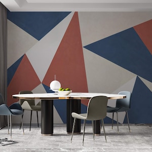 Può includere: Una sala da pranzo moderna con un tavolo bianco e sei sedie. La parete presenta un motivo geometrico in tonalità di rosso, blu e bianco.