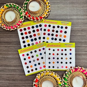 May include: Three gold candle holders with colorful fabric and white candles. Three sheets of paper with a variety of colored dots, labeled "Matching Plaza" and "Combination".