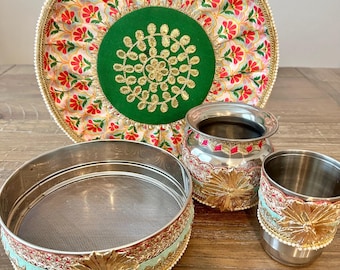 May include: A set of four decorative bowls with intricate gold and silver embellishments. The bowls are made of metal and have a traditional Indian design. The bowls are perfect for serving snacks, desserts, or other small items.
